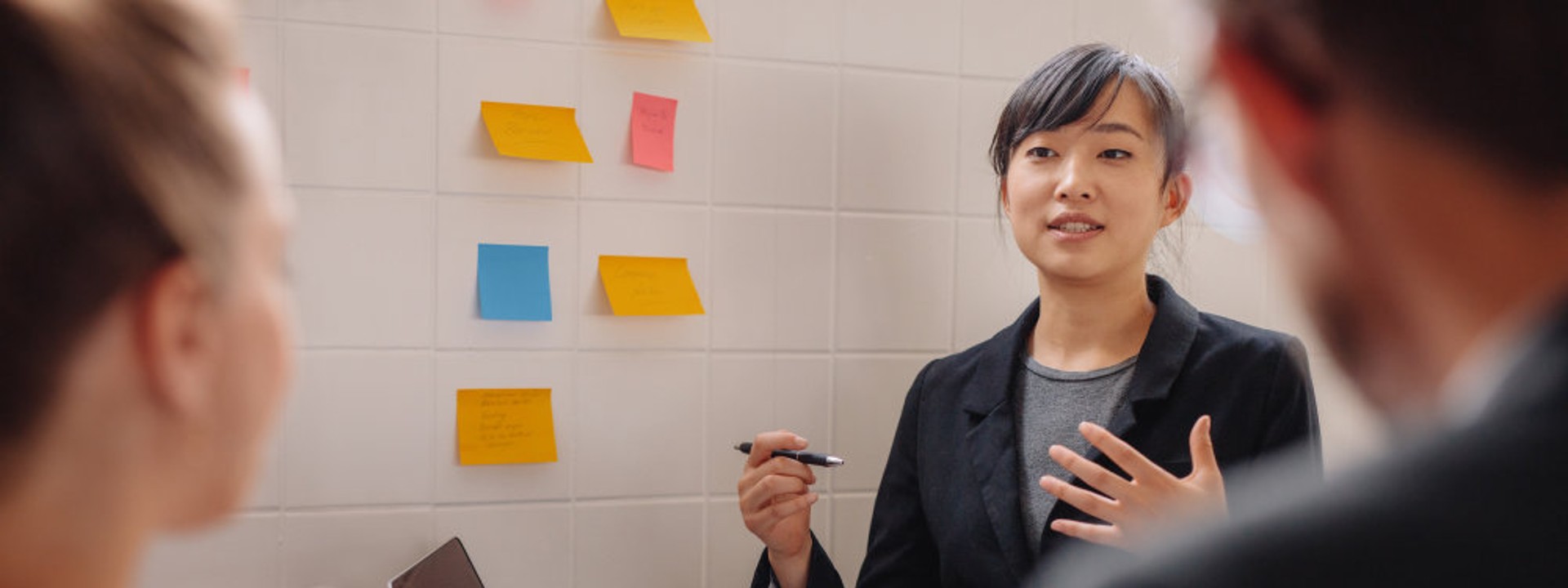 会議で発言している女性社員