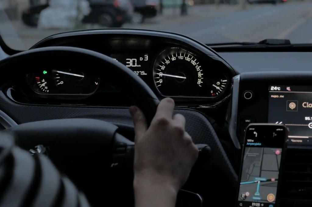 スマートフォンのナビゲーションアプリを使用しているドライバーが、周囲の交通を意識している状況