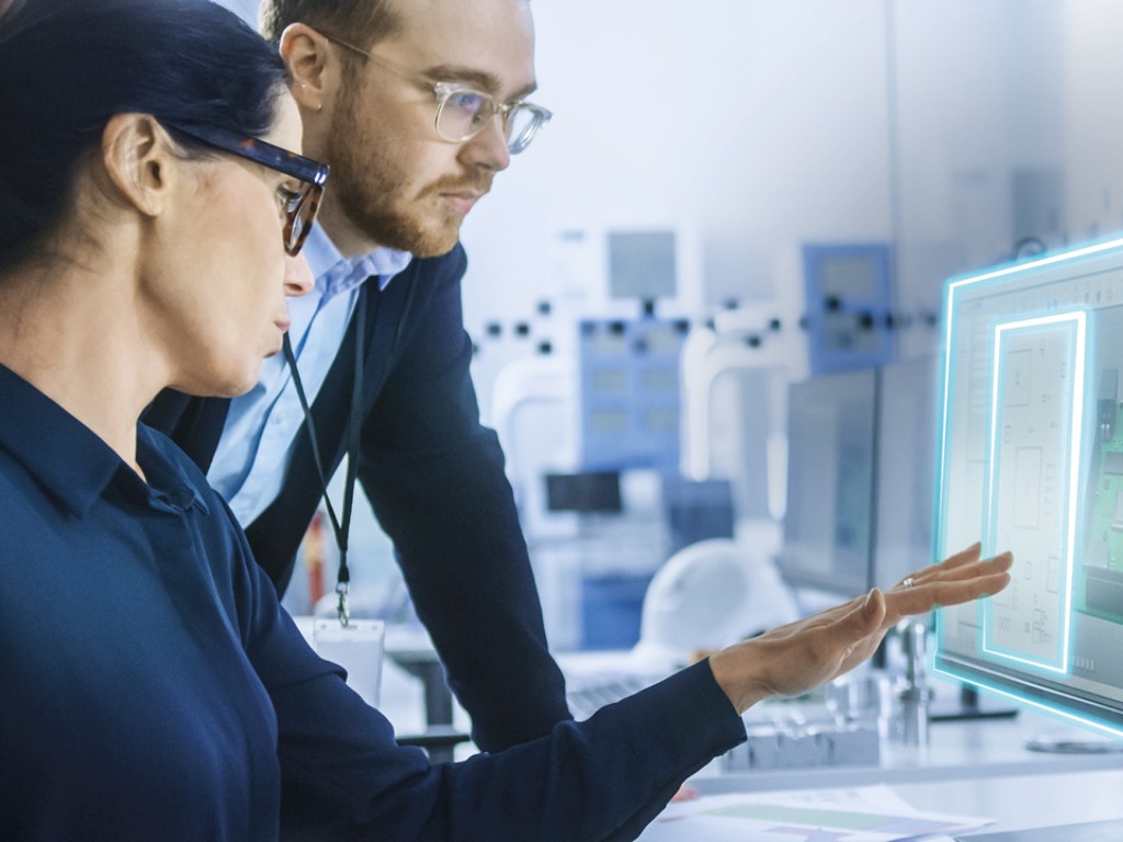 Zwei Mitarbeiter schauen auf einen Bildschirm