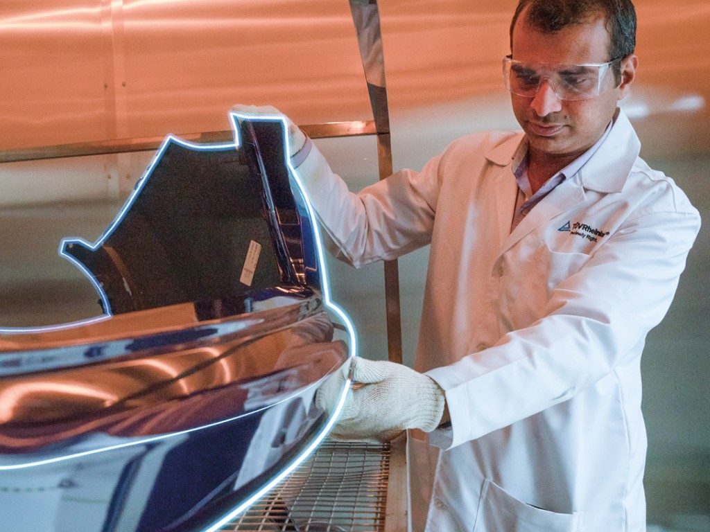 Person untersucht Komponente für Elektromobilität