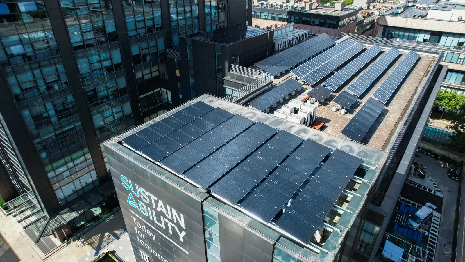Luftaufnahme des TÜV Rheinland Gebäudes in Greater China mit Photovoltaikanlage auf dem Dach und Sustainability-Schriftzug