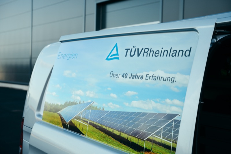 Rear of a service vehicle showing an advertisement with solar panels and renewable energy imagery